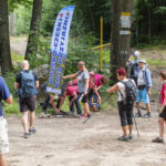 ludzie w turystycznych strojach wokół flagi polsko-czeski rajd przyjaźni