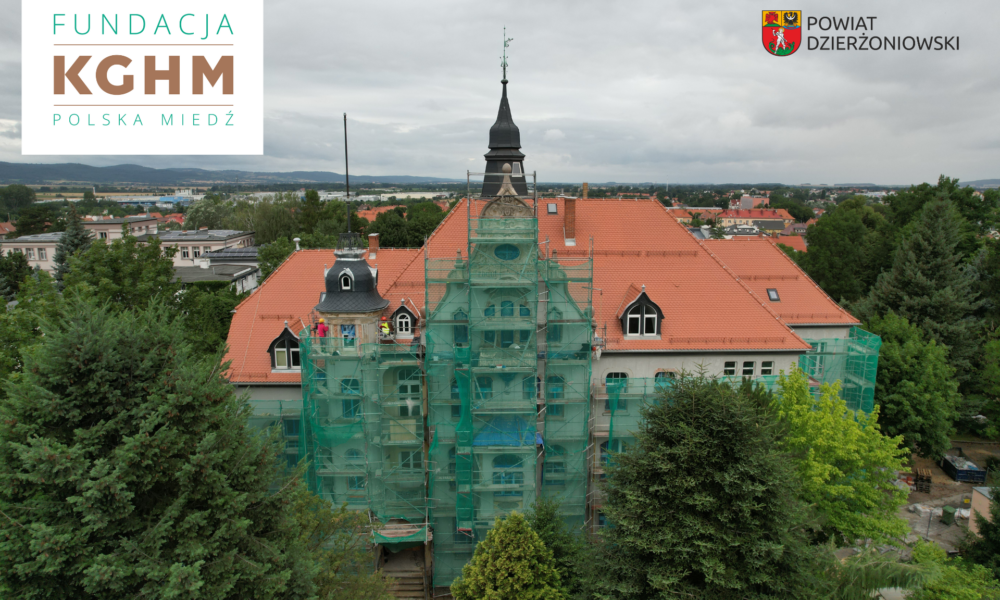 Fundacja KGHM Polska Miedź wspiera modernizację Zespołu Szkół nr 1 w Dzierżoniowie, dach szkoły, logo kghm i herb powiatu