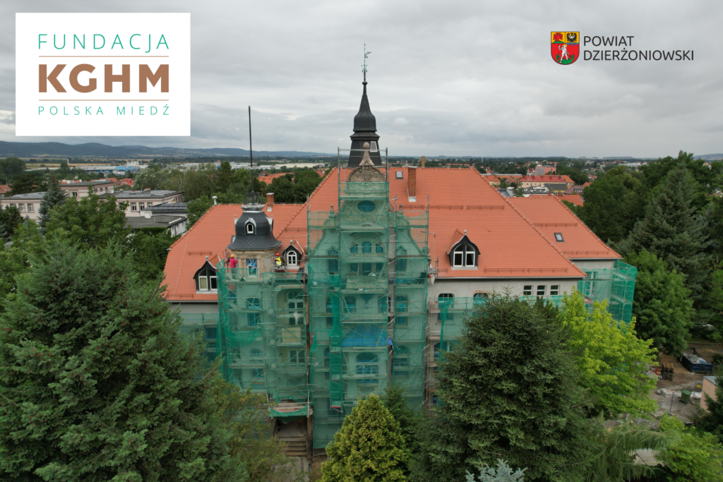 Fundacja KGHM Polska Miedź wspiera modernizację Zespołu Szkół nr 1 w Dzierżoniowie, dach szkoły, logo kghm i herb powiatu