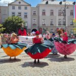 4 osoby w kolorowych strojach na czele korowodu