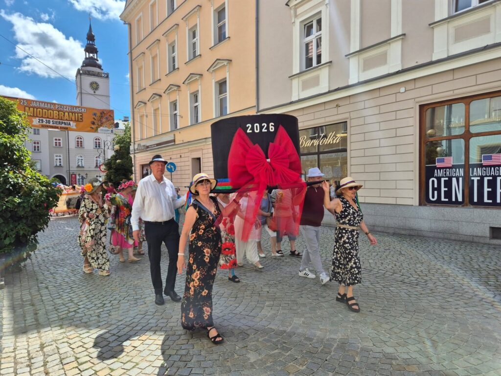 korowód niosący wielki kapelusz, obok poseł
