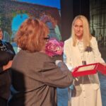 sekretarz i dyrektor edukacji wręczają plakietę dla dyrektor szkoły