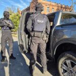 policja z bronią przy samochodzie