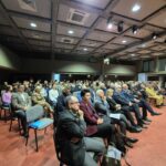 sala ludzie siedzą na krzesłach