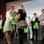dyrektor wręcza nagrodę dla uczniów nagrodzonych