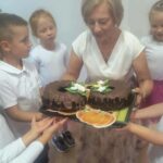 dyrektor z dziećmi i ciastami